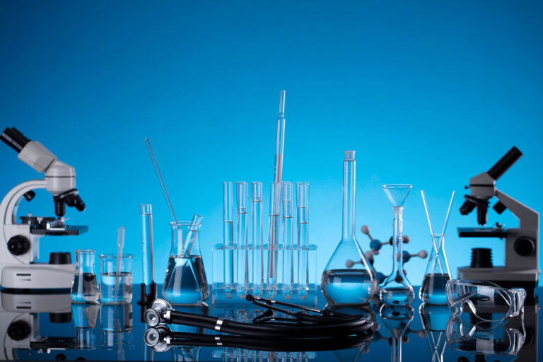 Laboratorierör, trattar, bägare, mikroskop och Erlenmeyer-kolvar som används vid ultraljudsrengöring.