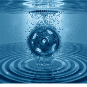 Metallväxel nedsänkt i blått vatten med bubblor som symboliserar ultraljudsrengöring av komplexa föremål.